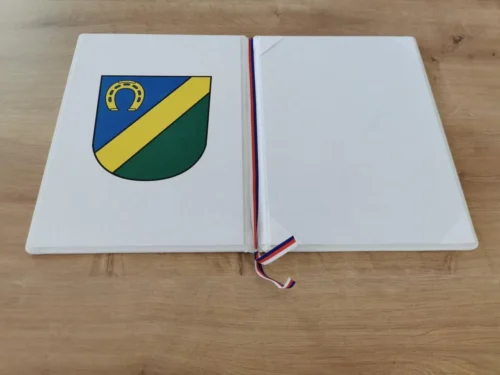 pamětní desky bílé se znakem obce Včelná