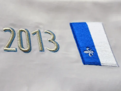 ručně šité písmo a vlajka na sametové stuze