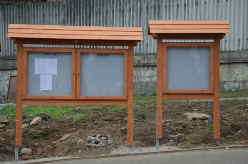 samostatně stojící dřevěná úřední deska se sedlovou střechou venkovní