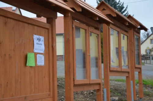 samostatně stojící dřevěná úřední deska se sedlovou střechou venkovní