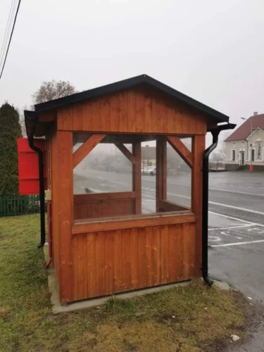 dřevěná autobusová zastávka se sedlovou střechou