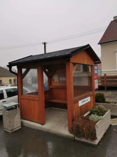 dřevěná autobusová zastávka se sedlovou střechou