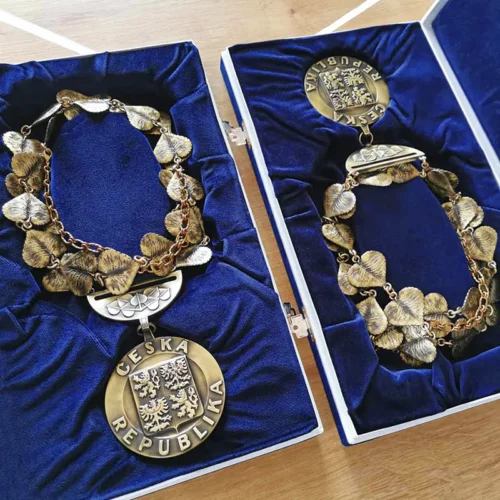 kovové insignie v sametových krabičkách